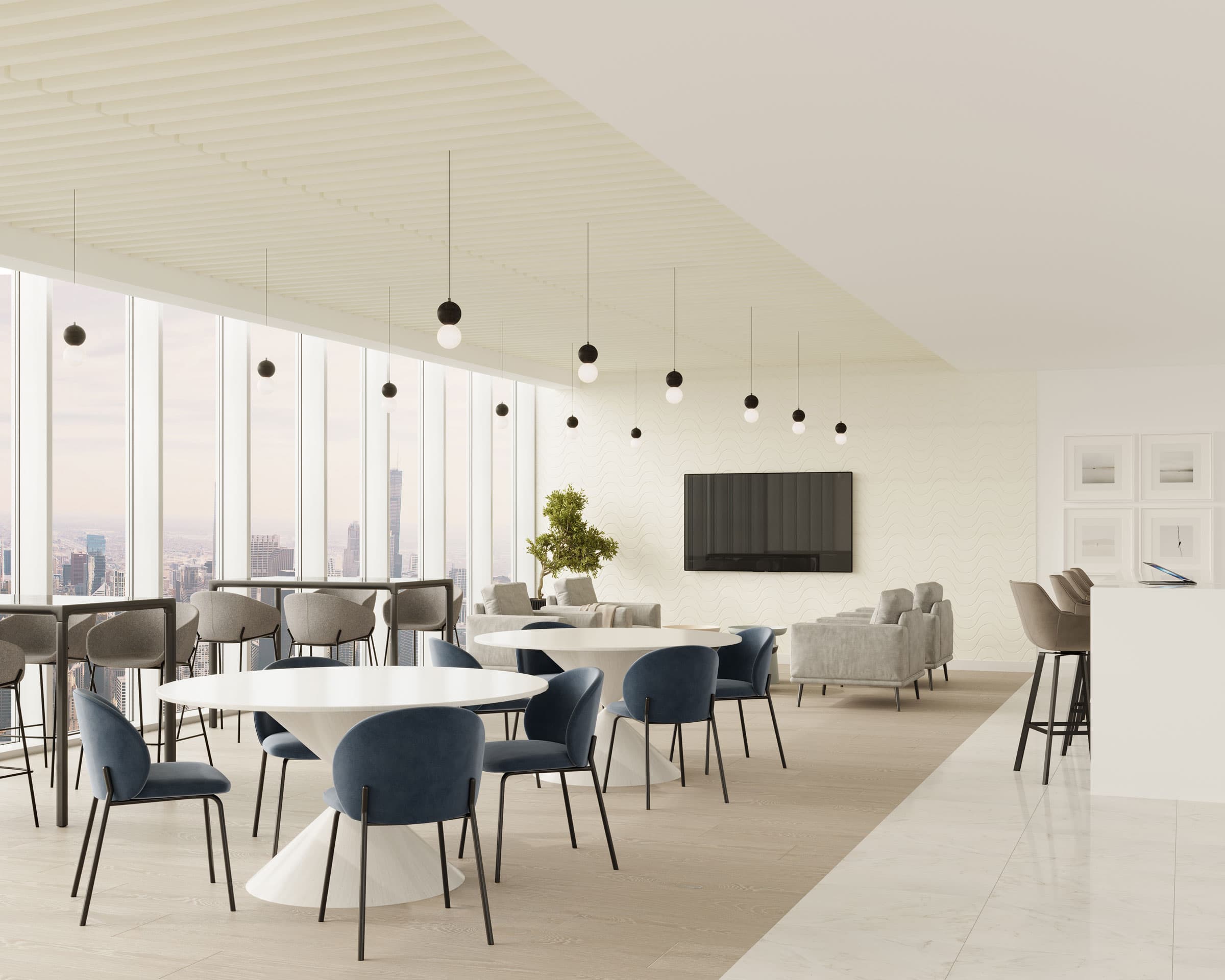A modern, spacious office lounge with large windows offering a city view. The room features round white tables with blue and grey chairs, a row of bar stools at a counter, a flat-screen TV mounted on the wall, and minimalistic black pendant lights hanging from the ceiling that features truss acoustic felt ceiling baffles.