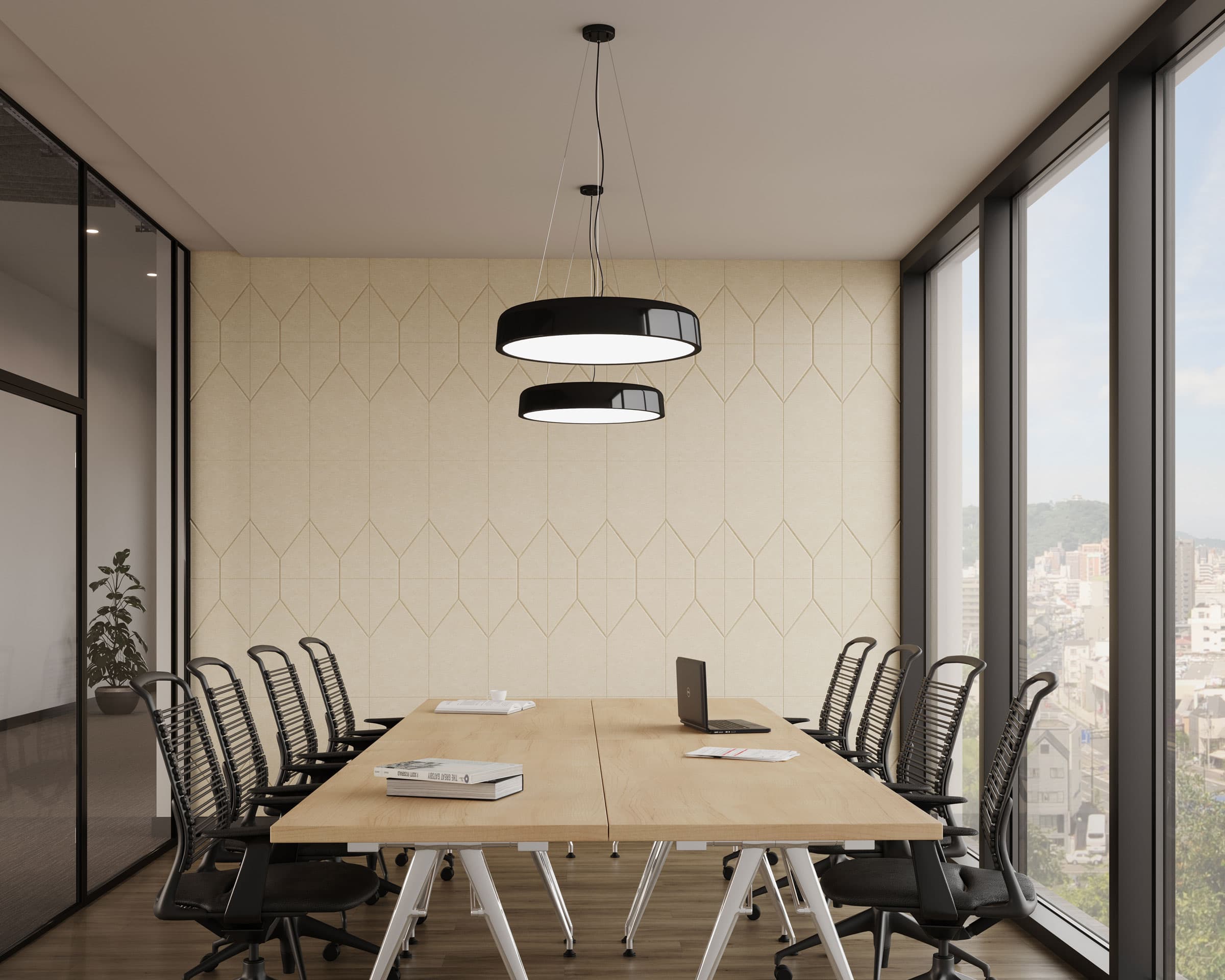 A modern conference room with a wooden table surrounded by black mesh office chairs. A laptop is on the table, which stands on an industrial metal base. Two circular ceiling lights hang above. Large windows offer a view of the cityscape and bring in natural light, while acoustic felt wall tiles ensure sound clarity.