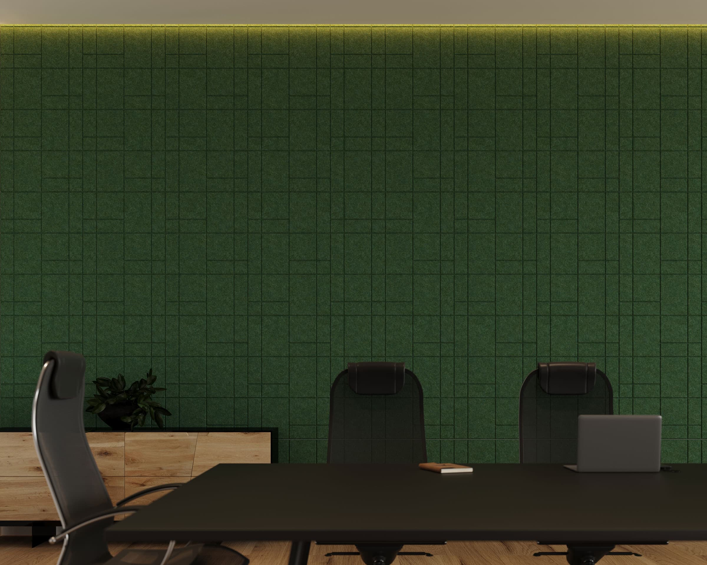 A minimalist conference room with a dark green grid-patterned wall and acoustic felt wall tiles, a black conference table, and black chairs. A laptop and a notepad are on the table. A wooden cabinet with a plant is against the wall. Subtle overhead lighting illuminates the room.