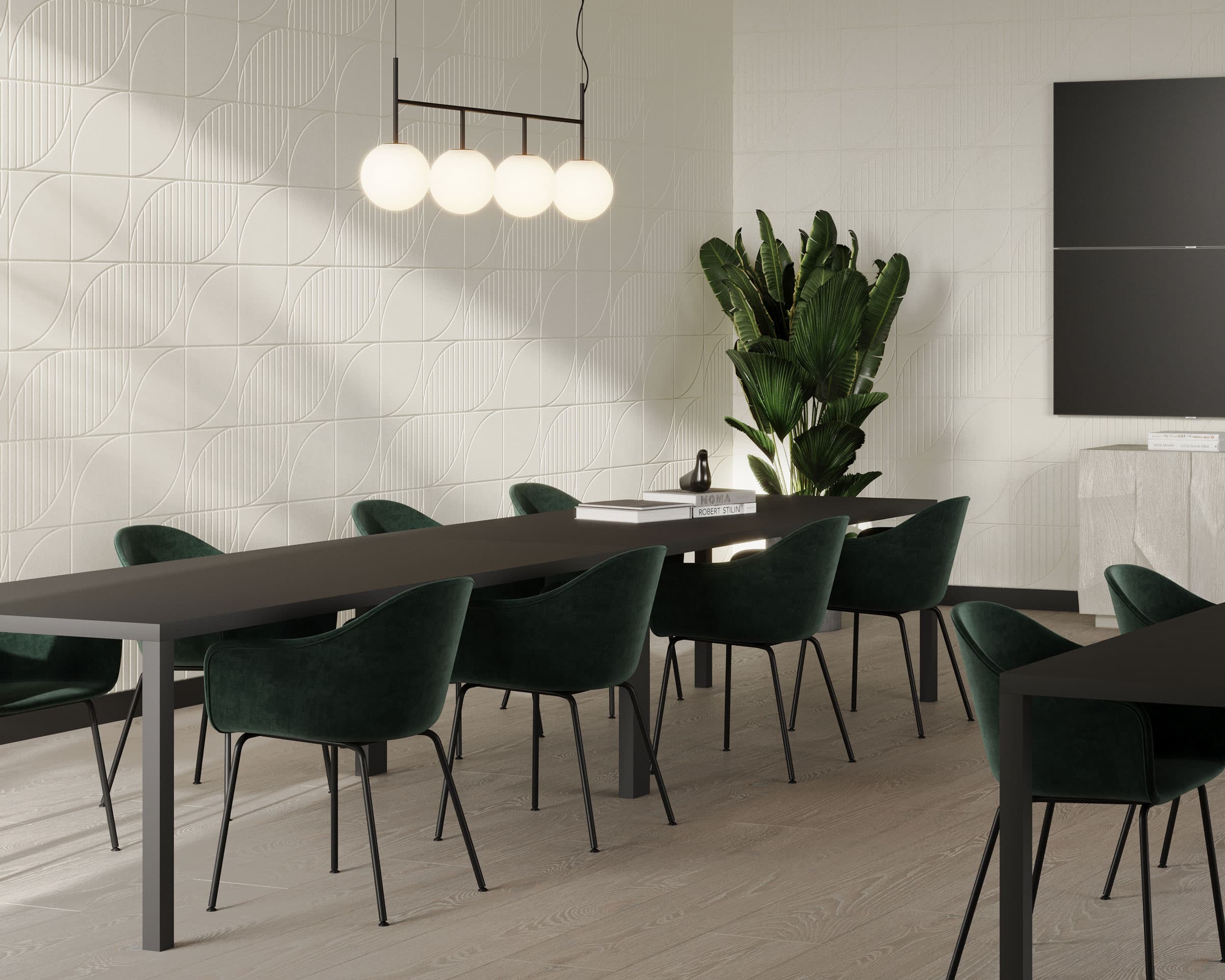 Modern dining room with a long dark table and green velvet chairs. A cluster of spherical pendant lights hangs above the table. A potted plant stands in the corner, and textured white walls with acoustic felt wall tiles complement the room’s minimalist design.
