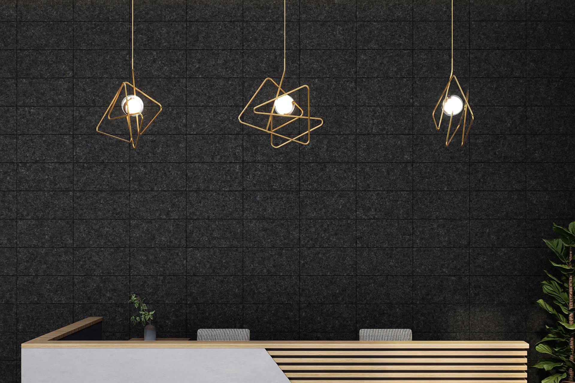 A modern reception area with a wooden desk featuring a diagonal white accent. Above the desk hang three geometric pendant lights with exposed bulbs against a dark textured acoustic felt wall. A small plant sits on the desk, and a tall plant is seen to the right.