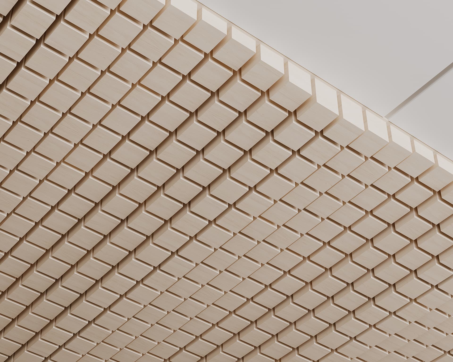 A ceiling featuring an intricate design of uniformly aligned acoustic felt blocks. The blocks protrude slightly, creating a textured and geometric pattern that spans the entire visible surface. The lighting accentuates the natural wood tones and the precise craftsmanship.