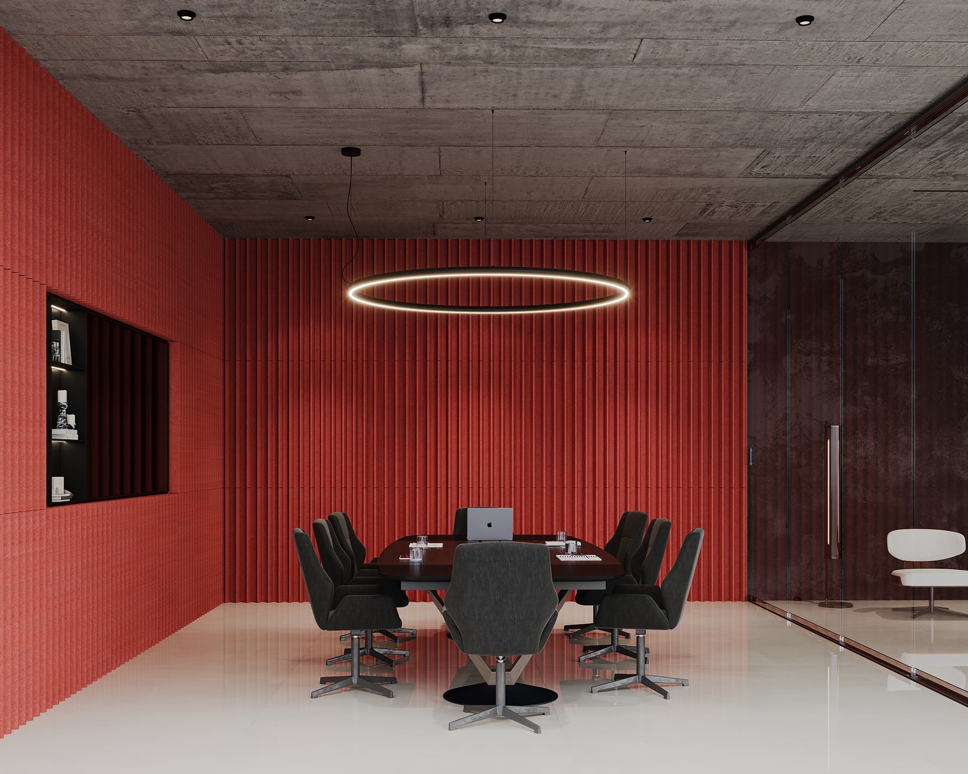 Modern conference room with a long table and eight black chairs. A laptop is on the table. The red-textured acoustic felt wall panels contrast with the gray ceiling. A circular pendant light hangs above. Glass partition on the right with a glimpse of another white chair.