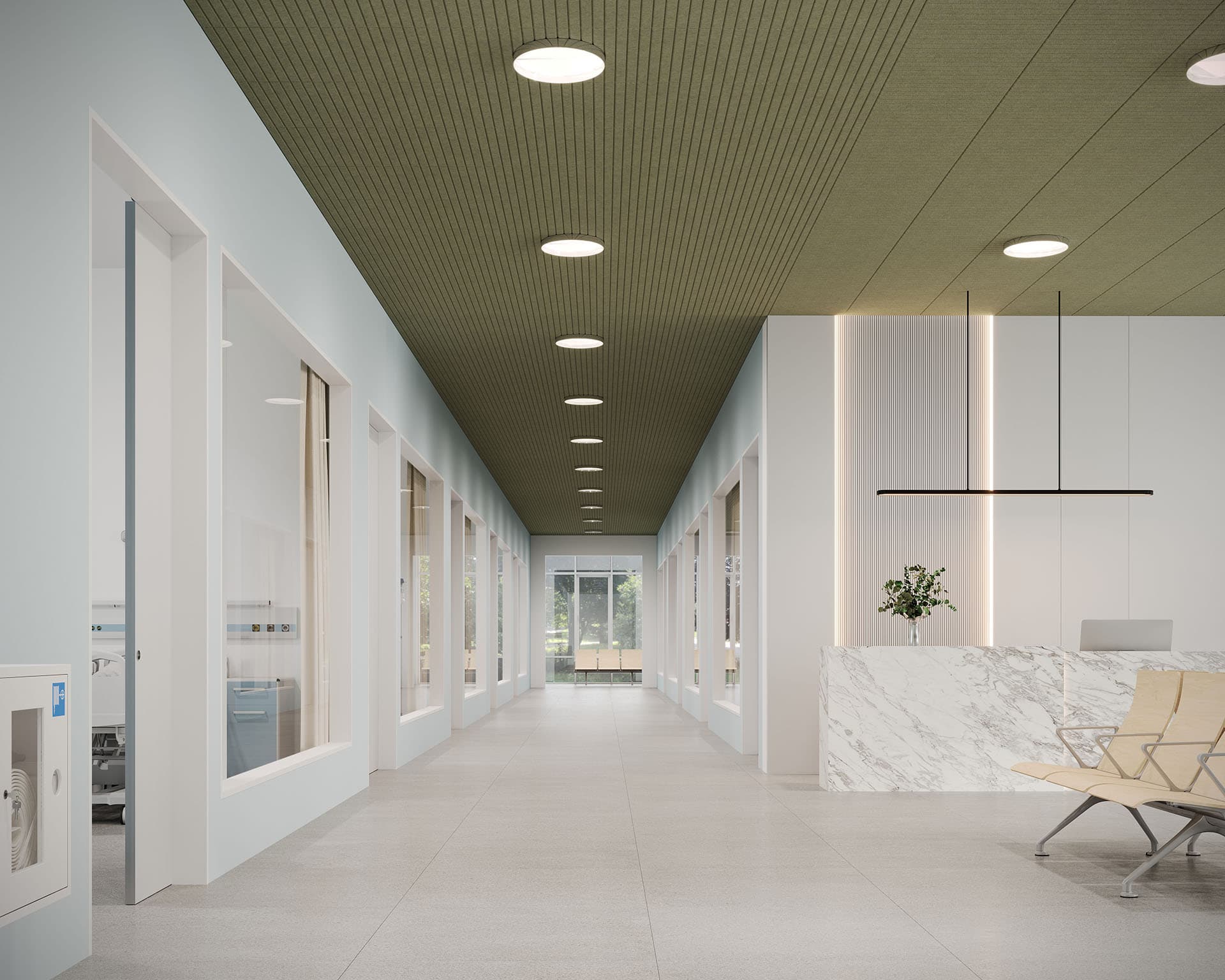 A modern hallway features light gray flooring and a green acoustic felt ceiling with circular lights. On the right, a marble reception desk holds a potted plant, complemented by nearby wood seating. Several glass-walled rooms line the left side, creating an inviting yet sophisticated ambiance.