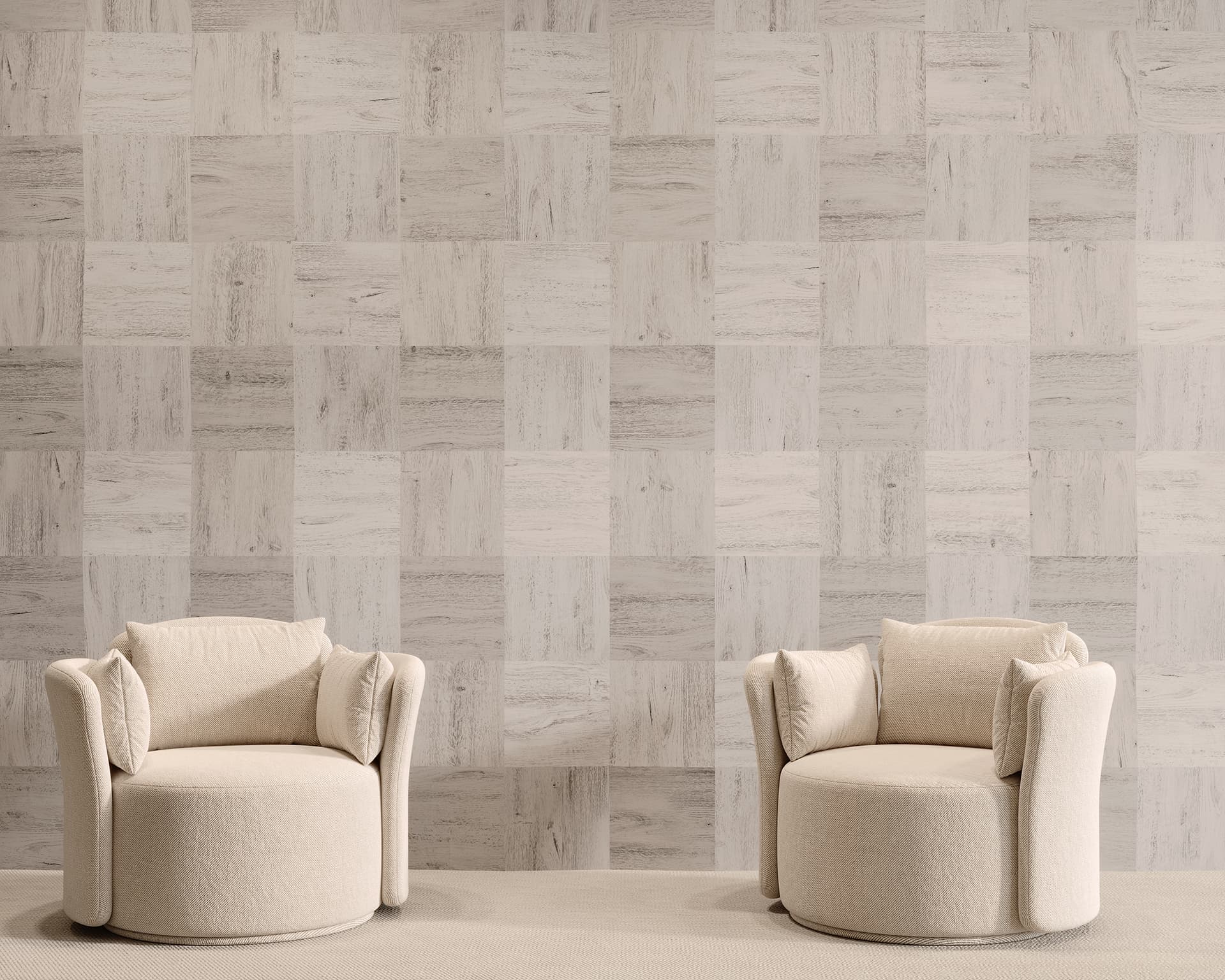 Two beige, round armchairs with cushioned backs sit facing the camera against a backdrop of slant textured, light-colored wall tiles. The chairs are placed on a light, solid-colored floor, creating a minimalist and modern setting.