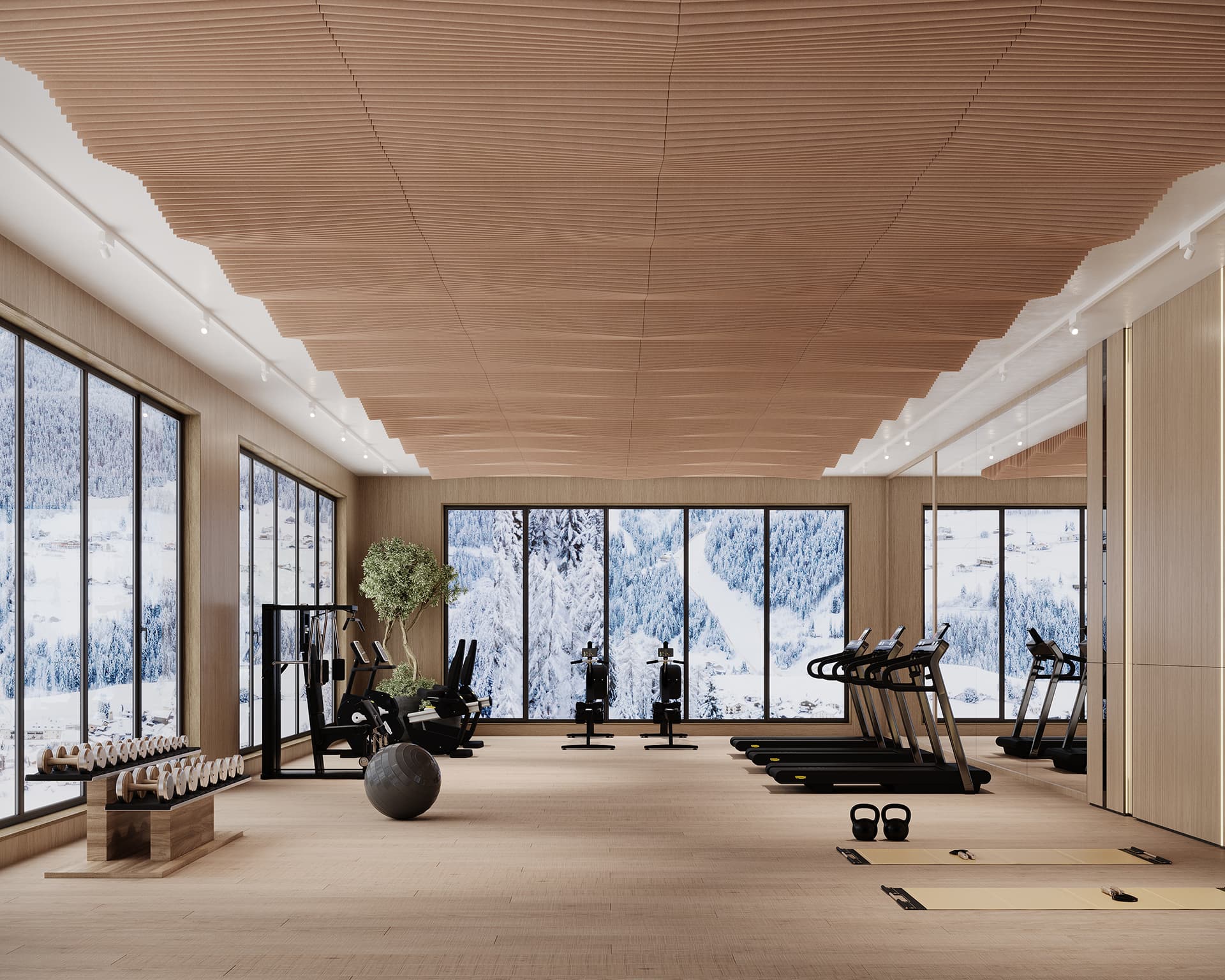 A modern gym with large windows offering a snowy mountain view. The room features treadmills, stationary bikes, a yoga mat, kettlebells, a large exercise ball, and neatly stacked water bottles. Warm lighting and an acoustic felt ceiling create a cozy atmosphere.