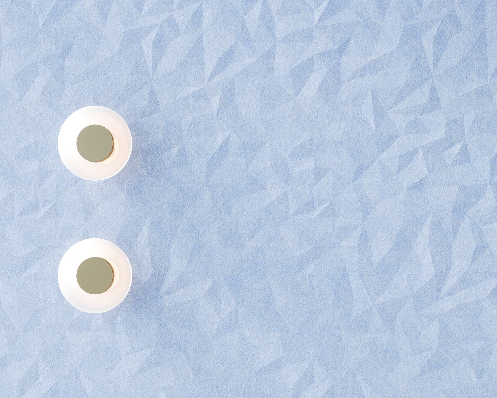 Two minimalistic, round, white light fixtures with a central circular gold accent are positioned on a textured, blue geometric-patterned acoustic felt wall. The lights are aligned vertically on the left side of the image.